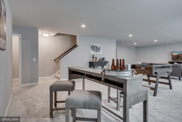 interior space with light carpet, stairway, recessed lighting, a textured ceiling, and baseboards