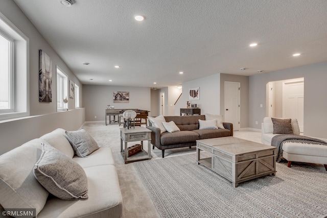 living area featuring light colored carpet, recessed lighting, a textured ceiling, and baseboards