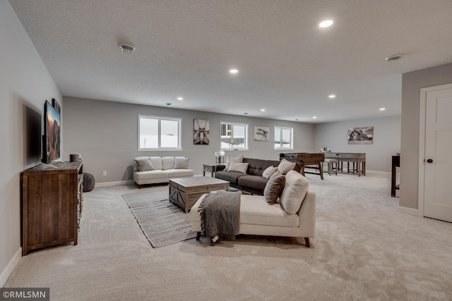 living room featuring light carpet, recessed lighting, baseboards, and a textured ceiling