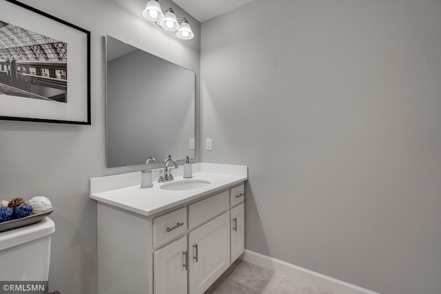 bathroom featuring vanity, tile patterned flooring, toilet, and baseboards