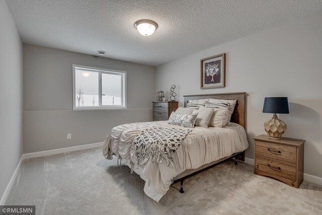 carpeted bedroom featuring baseboards and a textured ceiling