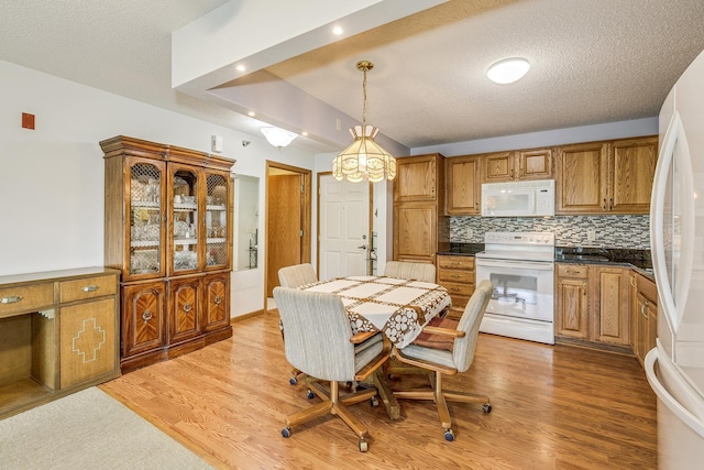 dining room featuring light wood finished floors and a textured ceiling