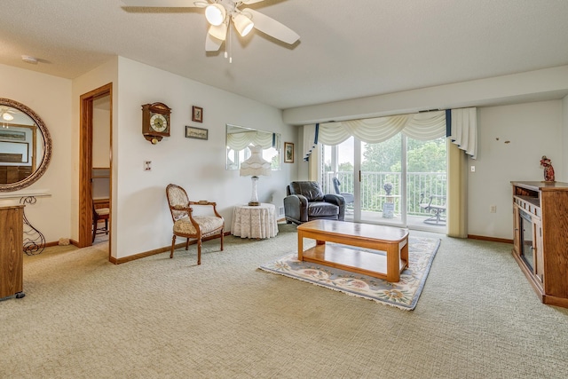 living area with light carpet, ceiling fan, and baseboards