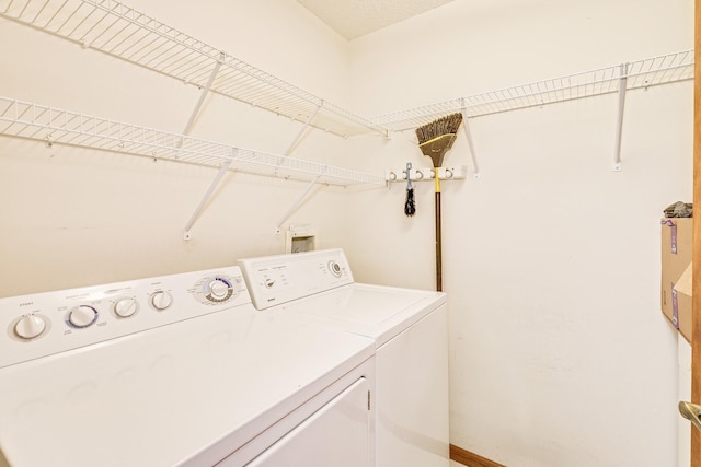 laundry area featuring washing machine and clothes dryer and baseboards