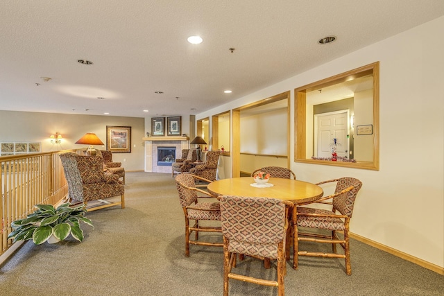 carpeted dining room featuring recessed lighting, a tile fireplace, and baseboards