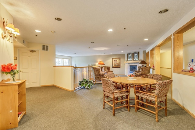 dining space with carpet, recessed lighting, baseboards, and a tile fireplace