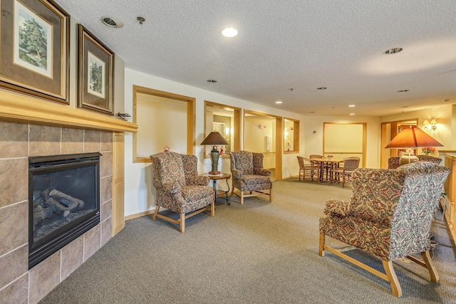 living room featuring carpet, a fireplace, a textured ceiling, recessed lighting, and baseboards