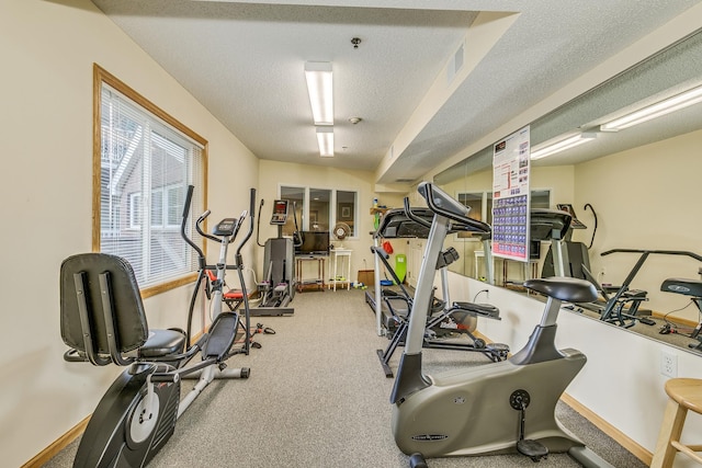 workout room featuring carpet flooring, baseboards, and a textured ceiling