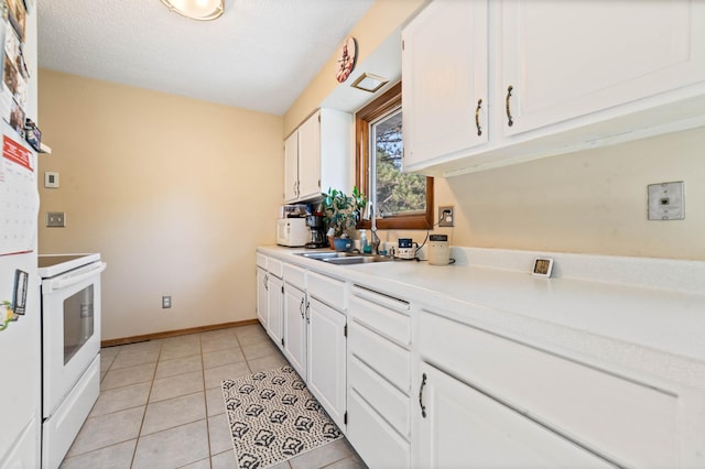 kitchen with a sink, white electric range oven, white cabinetry, and light countertops
