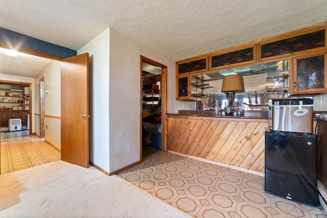 kitchen featuring baseboards, glass insert cabinets, and wooden walls