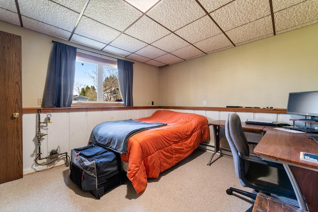 bedroom with a paneled ceiling, carpet flooring, and a desk