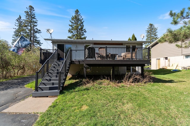 back of house with stairway, a wooden deck, and a yard
