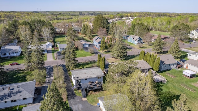 aerial view of property's location featuring nearby suburban area and a forest
