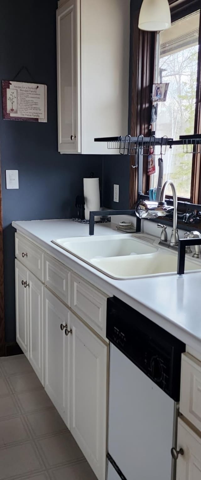 30091 Sunny Beach Rd, Harris Twp, MN 55744 - kitchen featuring dishwasher, light countertops, a sink, and white cabinetry