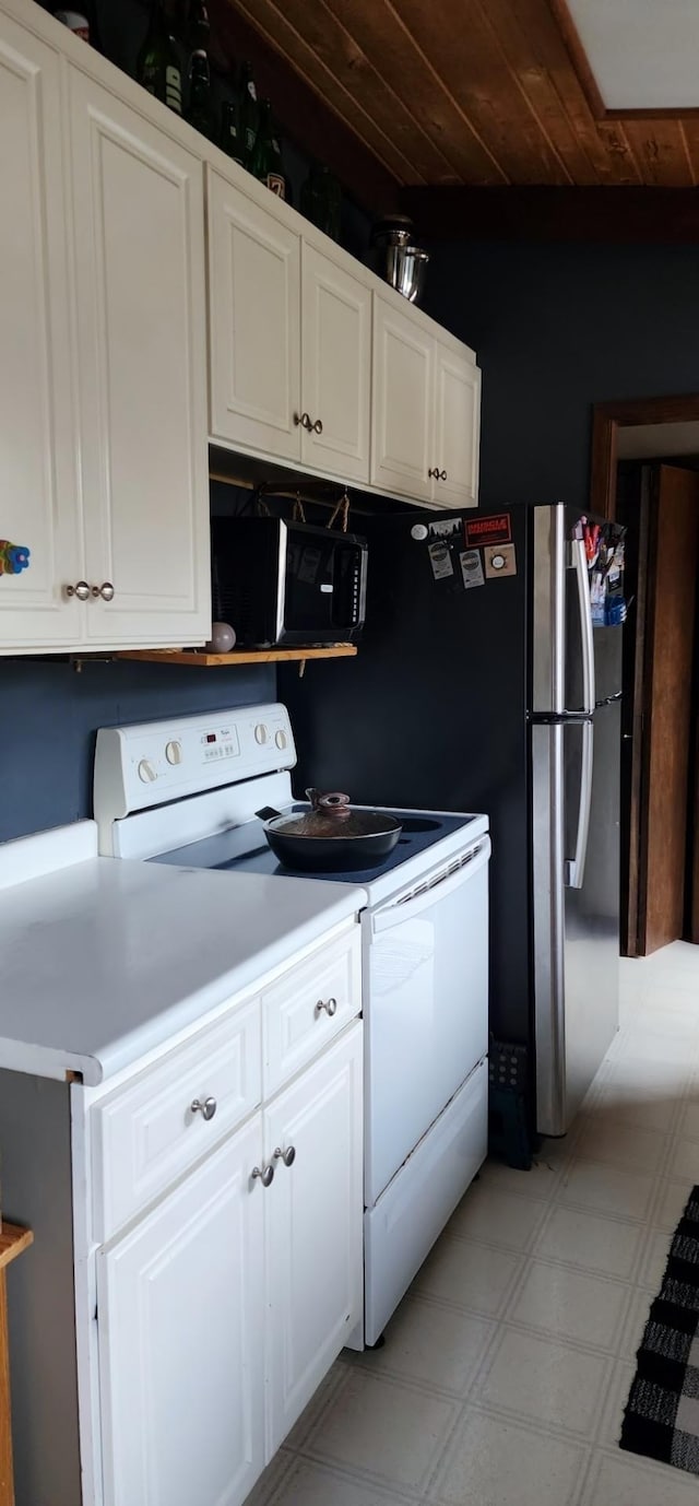 30091 Sunny Beach Rd, Harris Twp, MN 55744 - kitchen with electric range, black microwave, white cabinetry, and wooden ceiling