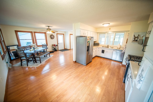 306 Hiawatha Dr E, Wabasha, MN 55981 - kitchen with stainless steel appliances, a sink, white cabinets, light countertops, and a textured ceiling