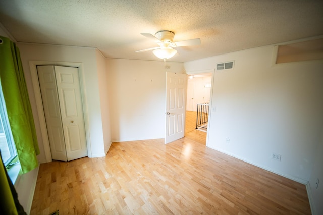 1723 Teton Ln NE, Rochester, MN 55906 - empty room with a ceiling fan, light wood finished floors, and a textured ceiling