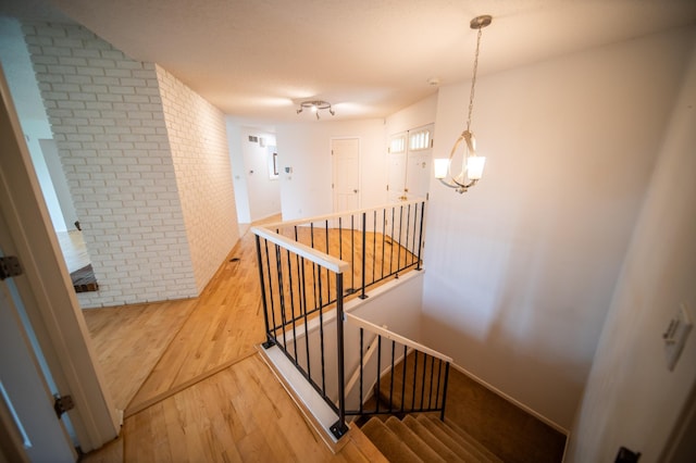 1723 Teton Ln NE, Rochester, MN 55906 - stairs featuring brick wall, wood finished floors, and baseboards