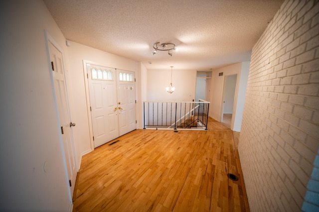 1723 Teton Ln NE, Rochester, MN 55906 - entrance foyer featuring a textured ceiling, light wood-style floors, and a chandelier