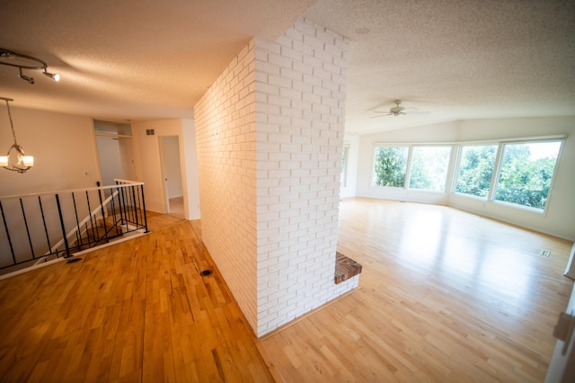 1723 Teton Ln NE, Rochester, MN 55906 - hall featuring a textured ceiling, an upstairs landing, wood finished floors, a chandelier, and vaulted ceiling