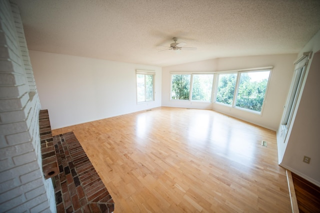 1723 Teton Ln NE, Rochester, MN 55906 - unfurnished living room with a ceiling fan, wood finished floors, vaulted ceiling, a textured ceiling, and baseboards