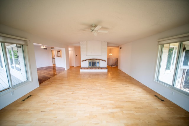 1723 Teton Ln NE, Rochester, MN 55906 - unfurnished living room with plenty of natural light, vaulted ceiling, ceiling fan, wood finished floors, and a fireplace