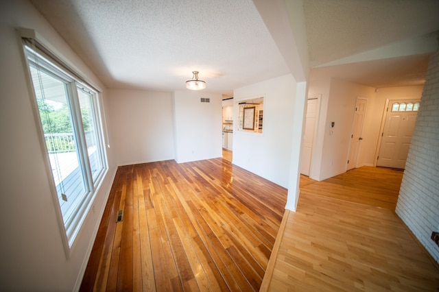 1723 Teton Ln NE, Rochester, MN 55906 - spare room with light wood-type flooring, a chandelier, a textured ceiling, and baseboards