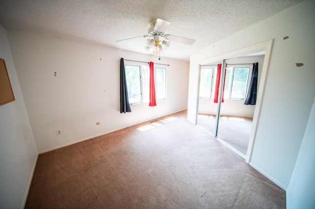 1723 Teton Ln NE, Rochester, MN 55906 - unfurnished bedroom featuring carpet floors, multiple windows, a closet, a textured ceiling, and ceiling fan