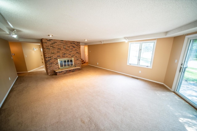 1723 Teton Ln NE, Rochester, MN 55906 - unfurnished living room featuring a textured ceiling, a fireplace, carpet flooring, baseboards, and healthy amount of natural light