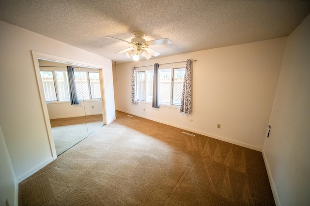 1723 Teton Ln NE, Rochester, MN 55906 - empty room with carpet, healthy amount of natural light, a ceiling fan, baseboards, and a textured ceiling