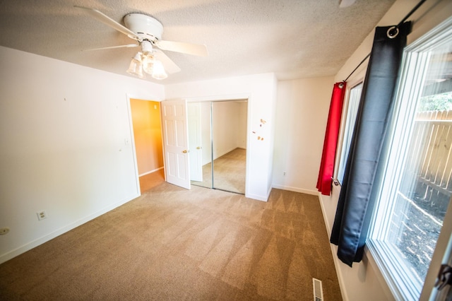 1723 Teton Ln NE, Rochester, MN 55906 - unfurnished bedroom featuring a textured ceiling, carpet floors, a ceiling fan, a closet, and baseboards