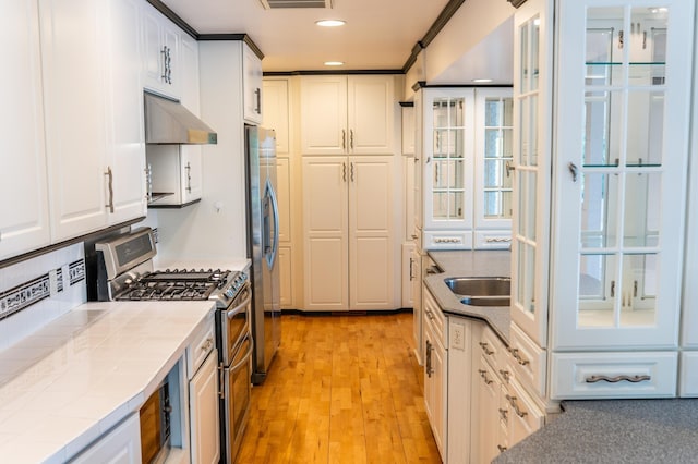 1723 Teton Ln NE, Rochester, MN 55906 - kitchen with tile countertops, appliances with stainless steel finishes, under cabinet range hood, white cabinetry, and light wood-style flooring