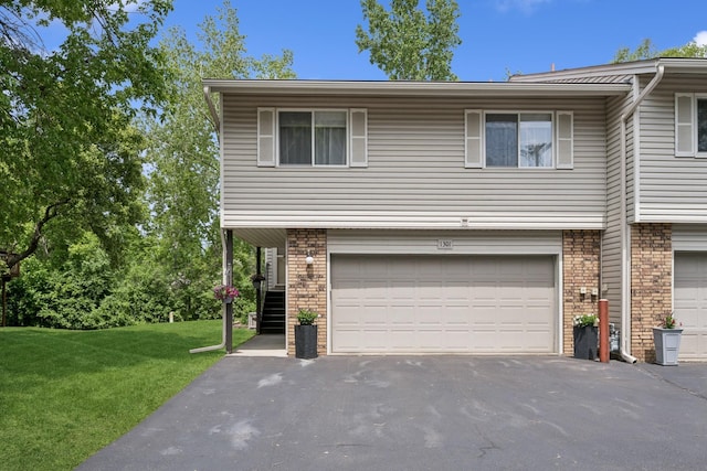1301 Crestridge Ln, Eagan, MN 55123 - view of front facade featuring an attached garage, asphalt driveway, a front yard, and brick siding