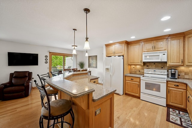 1301 Crestridge Ln, Eagan, MN 55123 - kitchen with white appliances, light wood-type flooring, a breakfast bar, backsplash, and recessed lighting