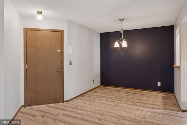 7475 110th St W, Bloomington, MN 55438 - unfurnished dining area with wood finished floors, baseboards, and a chandelier