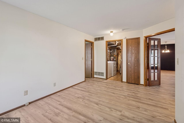 7475 110th St W, Bloomington, MN 55438 - unfurnished bedroom with wood finished floors, baseboards, a chandelier, washer / dryer, and connected bathroom