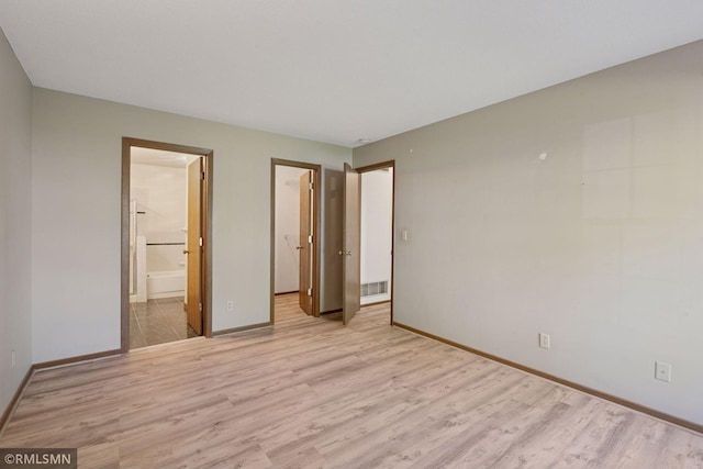 7475 110th St W, Bloomington, MN 55438 - unfurnished bedroom with light wood finished floors, baseboards, a spacious closet, and ensuite bath