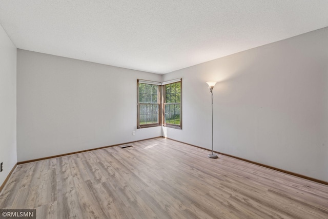7475 110th St W, Bloomington, MN 55438 - spare room with wood finished floors, baseboards, and a textured ceiling
