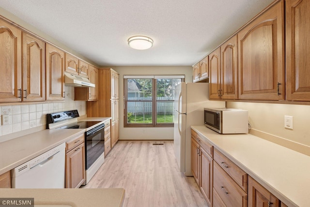 7475 110th St W, Bloomington, MN 55438 - kitchen featuring electric range oven, dishwasher, under cabinet range hood, stainless steel microwave, and light wood finished floors
