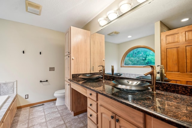 342 Soo Line Rd, Troy Twp, WI 54016 - full bathroom with a bath, double vanity, toilet, and baseboards