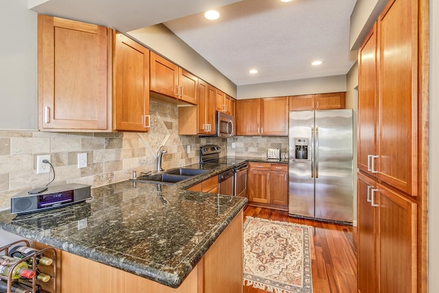 1709 140th St, Burnsville, MN 55337 - kitchen featuring stainless steel appliances, a sink, a peninsula, dark wood-style flooring, and brown cabinetry