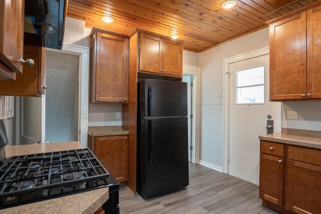 kitchen featuring black appliances, light wood-style floors, brown cabinets, light countertops, and wood ceiling
