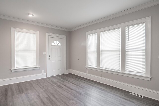 entrance foyer with dark wood-type flooring, ornamental molding, and baseboards