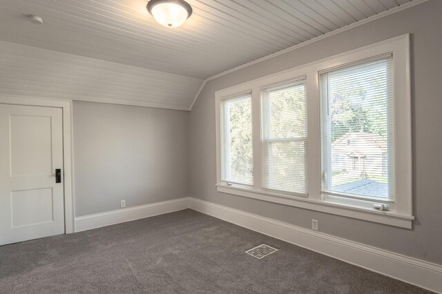 bonus room with dark colored carpet, lofted ceiling, baseboards, and wood ceiling