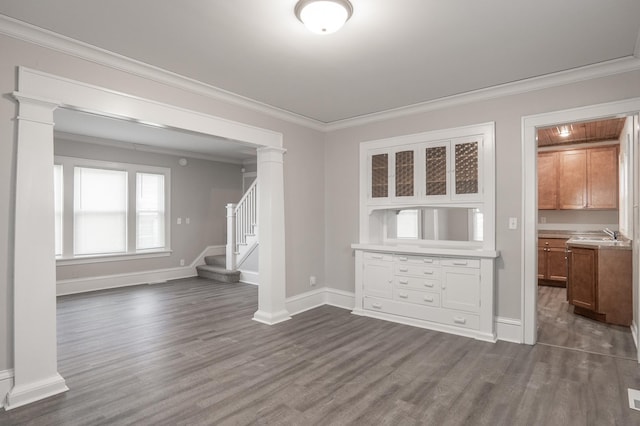 unfurnished dining area with dark wood-type flooring, ornamental molding, stairway, and baseboards