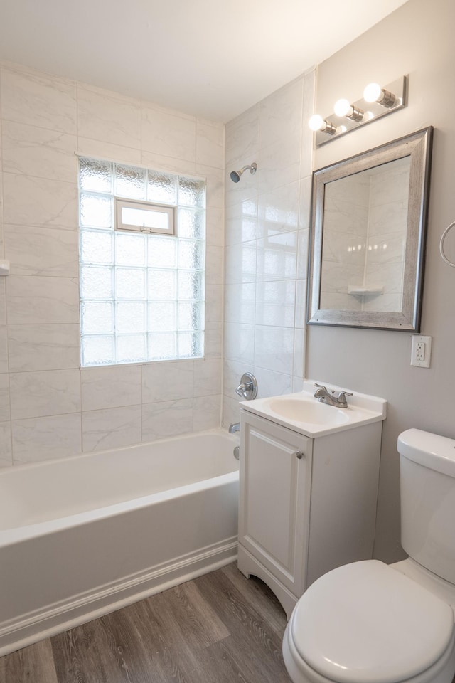 full bath featuring wood finished floors, bathing tub / shower combination, toilet, and vanity
