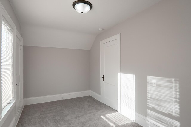 bonus room featuring carpet flooring, vaulted ceiling, and baseboards