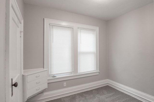 unfurnished bedroom featuring carpet floors, multiple windows, and baseboards