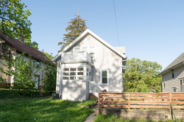 back of house with a balcony, fence, and central AC