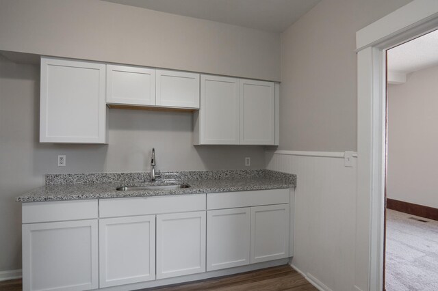 188 Wyoming St E, Saint Paul, MN 55107 - kitchen with a sink, white cabinets, light stone countertops, and wainscoting